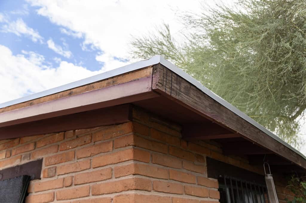 Explicación de Fascia y Soffit para Casas en Tucson 1 Revestimiento de madera envejecida con pintura descascarada en una casa de Tucson antes de un revestimiento de aluminio