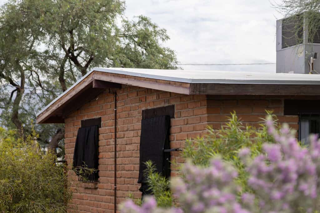 Sun-damaged wood fascia with cracked, faded finish on a Tucson home