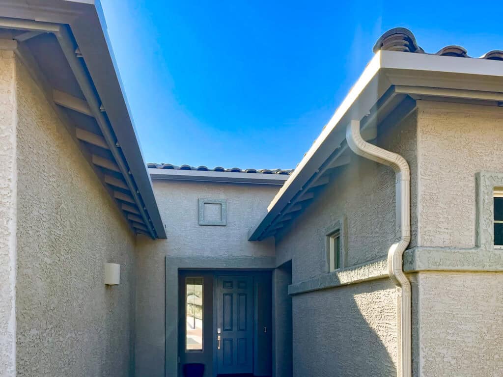 White seamless gutter and downspout at the entry of a Tucson, Arizona home