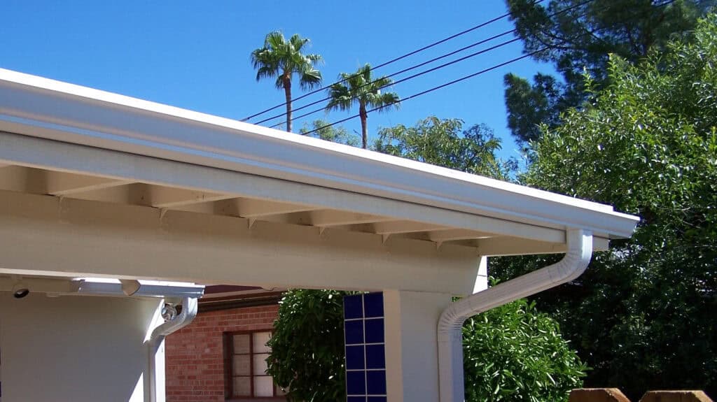 Close up of a white seamless gutter and downspout on a Tucson, Arizona home