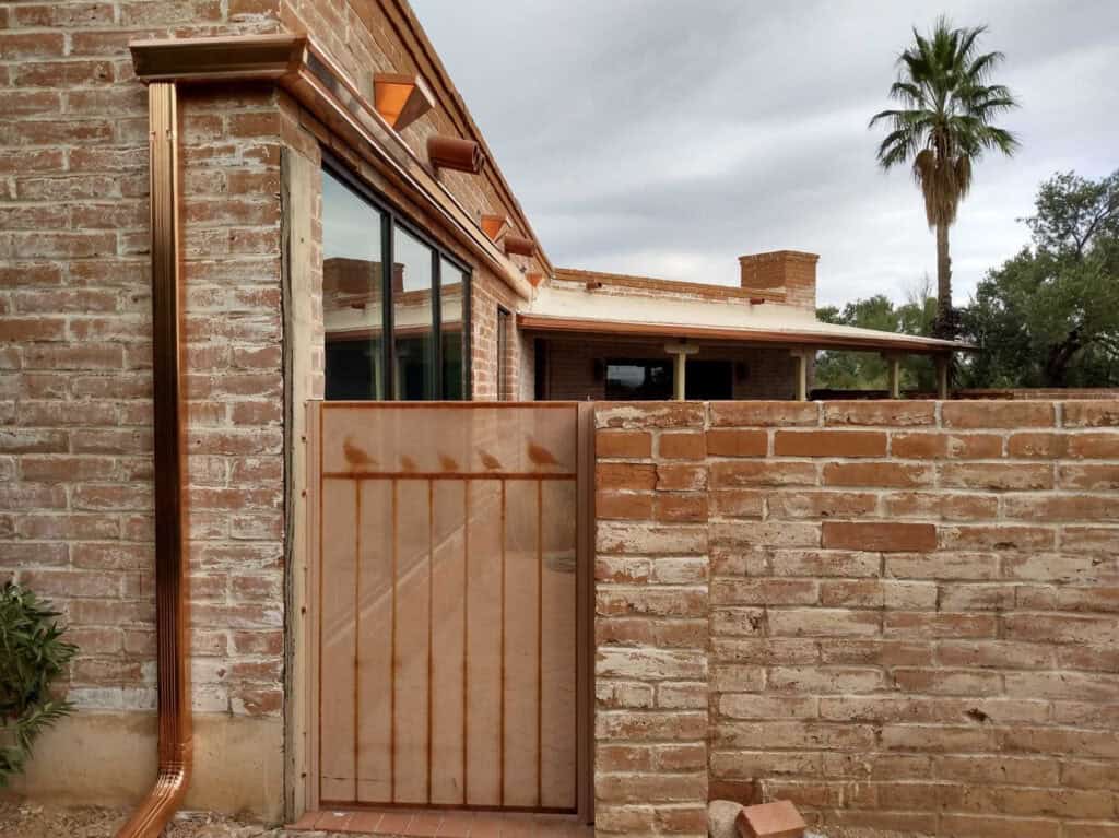 Copper downspout and copper scupper boxes on a brick home in Tucson, Arizona