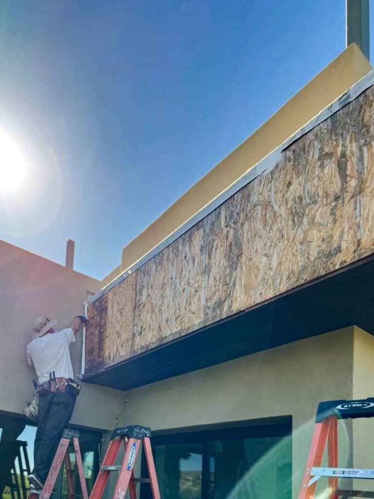 Installer fitting custom aluminum fascia wrap over exposed wood fascia in Tucson, Arizona
